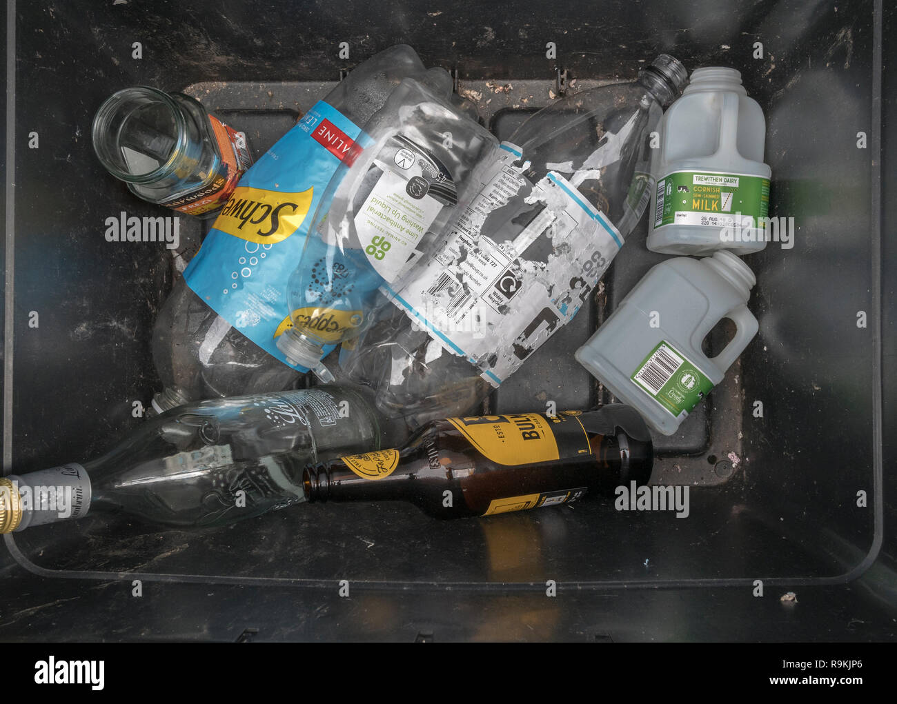 Domestic recycling box containing both plastic and glass bottles. Branded products so RM/Edit. Metaphor war on plastic, plastic recycling. Stock Photo