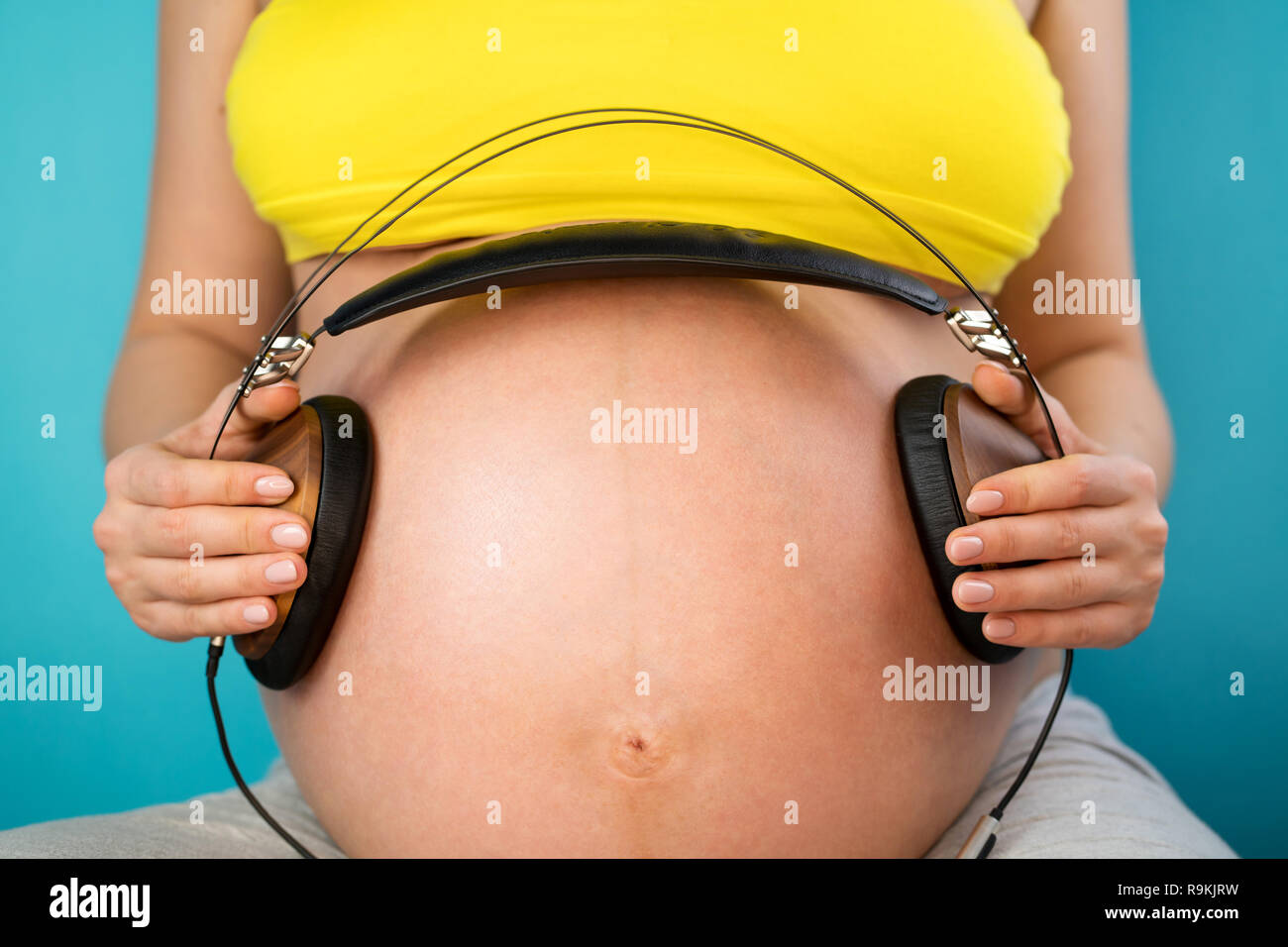 Pregnant Woman Holding Headphones On Her Belly Music For Baby Concept Pregnancy  And Music Stock Photo - Download Image Now - iStock
