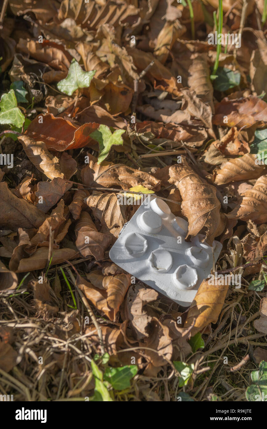 Plastic tablet blisterpack / blister-pack discarded in rural hedgerow. Metaphor plastic pollution, environmental pollution, war on plastic waste. Stock Photo