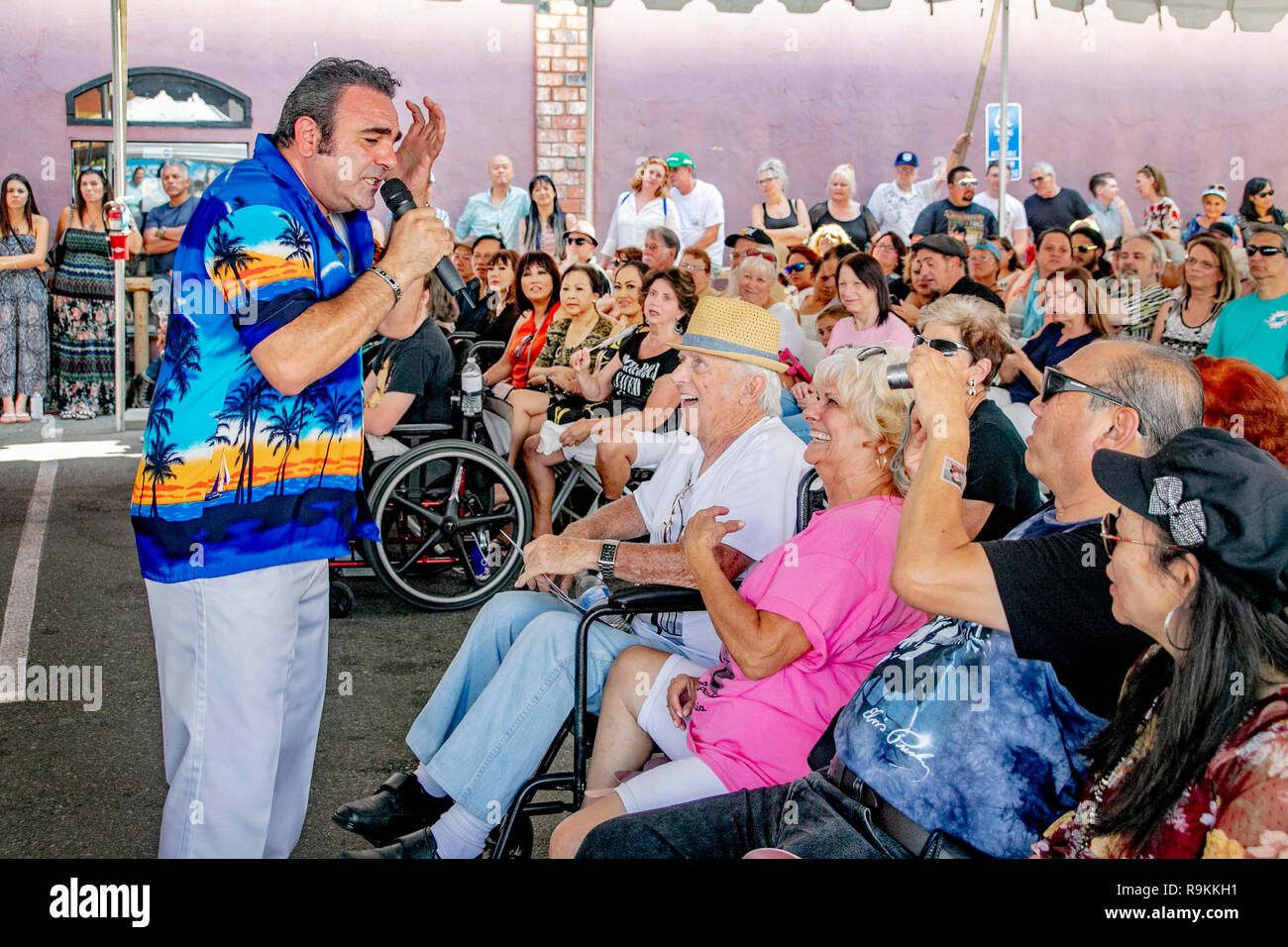 Performing rock 'n' roll classic songs, an enthusiastic singer charms young and old audience members at a music festival in Fullerton, CA. Stock Photo
