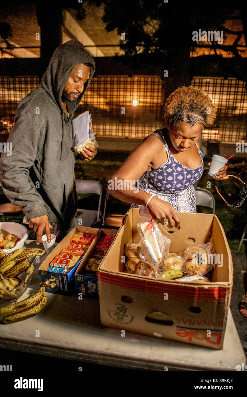 Released county jail inmates get free food from a charity van on the street a night in Santa Ana, CA. Stock Photo