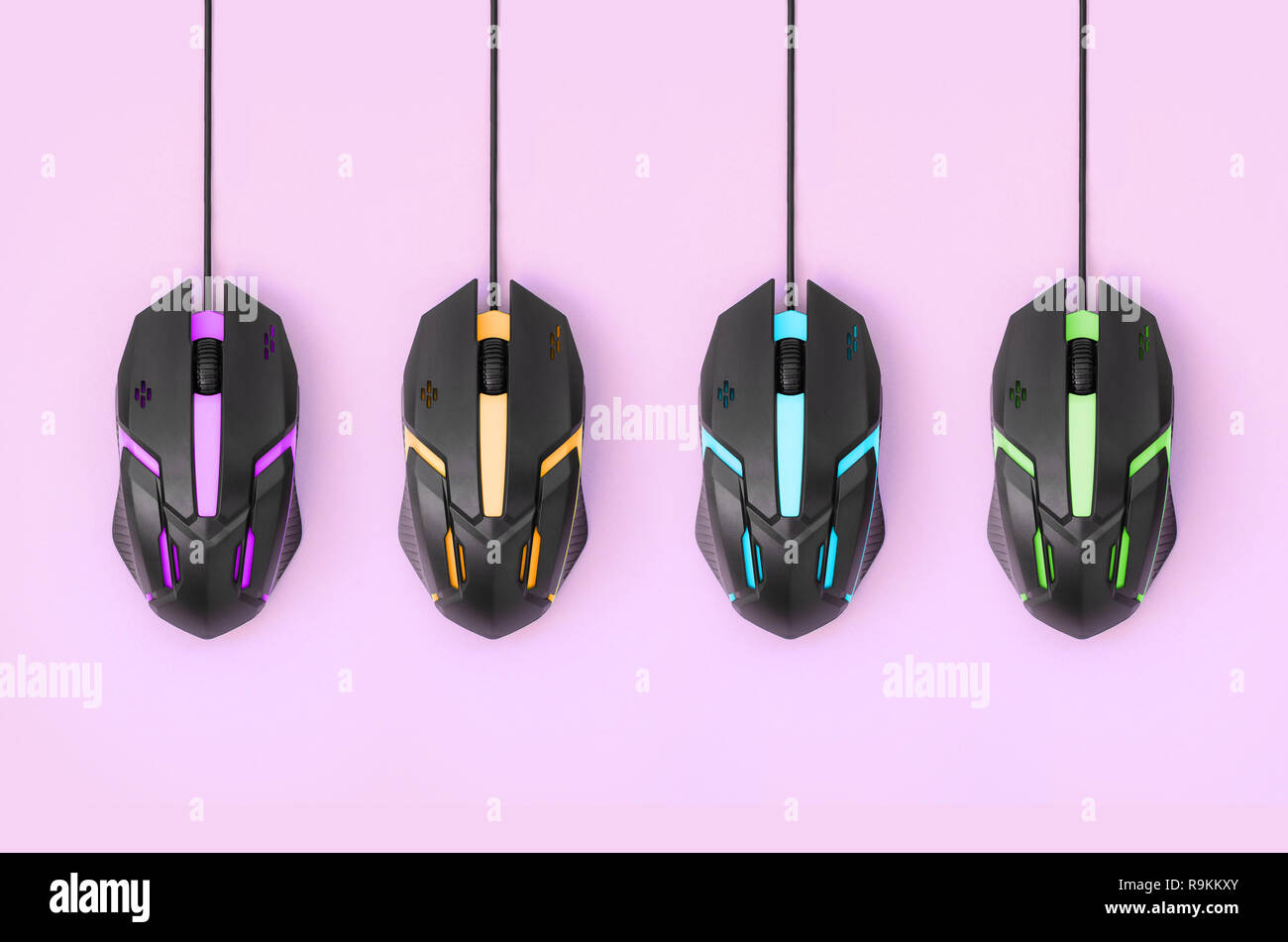 Several computer mice hang on a pastel pink background. The concept of  cooperative computer video games, the use of auto-clicker and pay-per-click  pla Stock Photo - Alamy