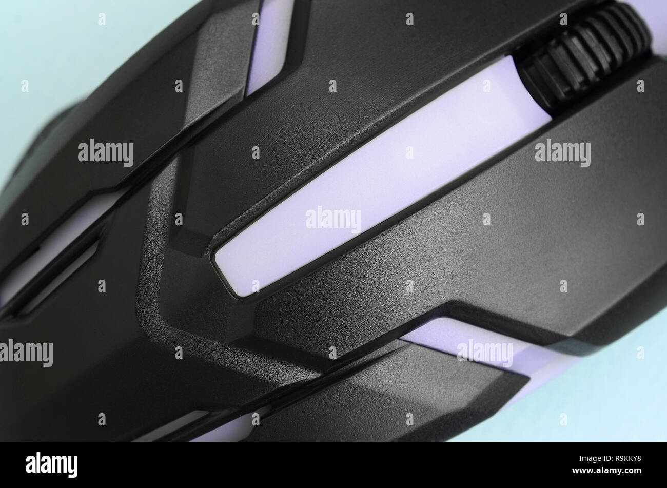 Closeup of a black gaming optical mouse on a blue background. Device ...