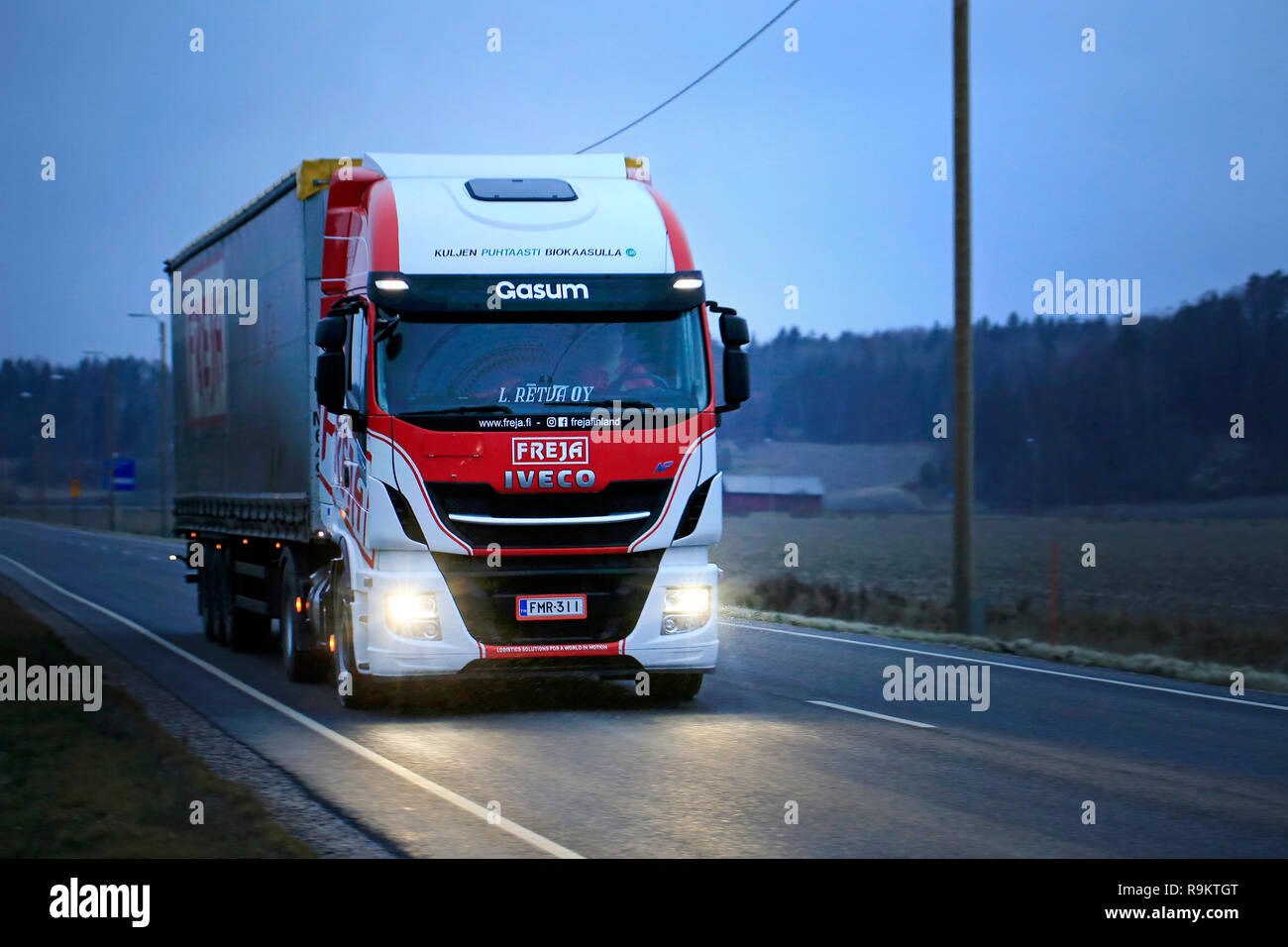 Salo, Finland - December 16, 2018: Biogas fueled Iveco Stralis NP truck L. Retva Oy pulls FREJA trailer along highway on cloudy winter evening. Stock Photo