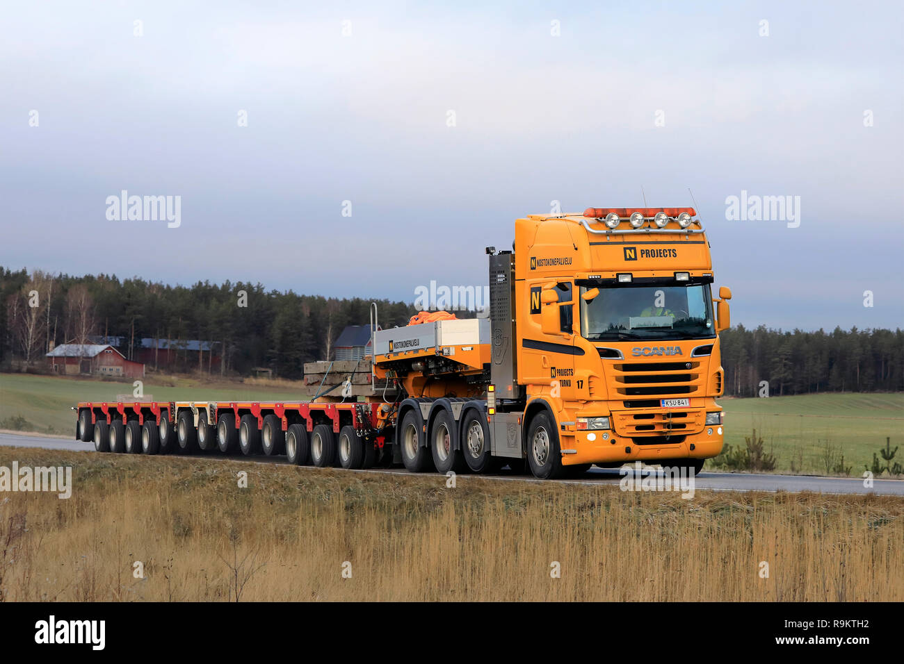 Salo, Finland - December 14, 2018: Yellow Scania semi in front of multi axle trailer for heavy transport of Nostokonepalvelu on the road in Finland. Stock Photo