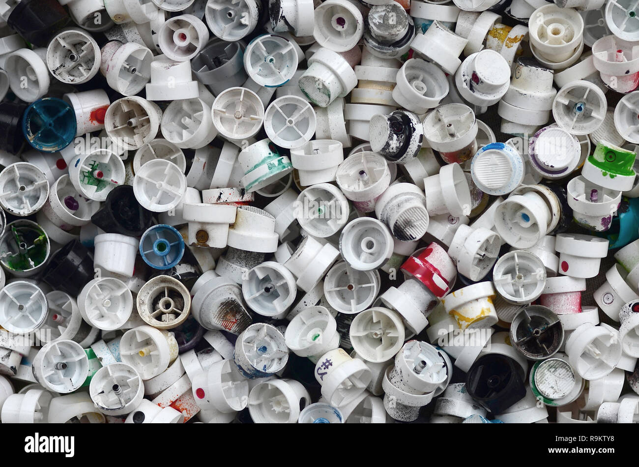 A pattern of many used and soiled nozzles from spray cans with aerosol