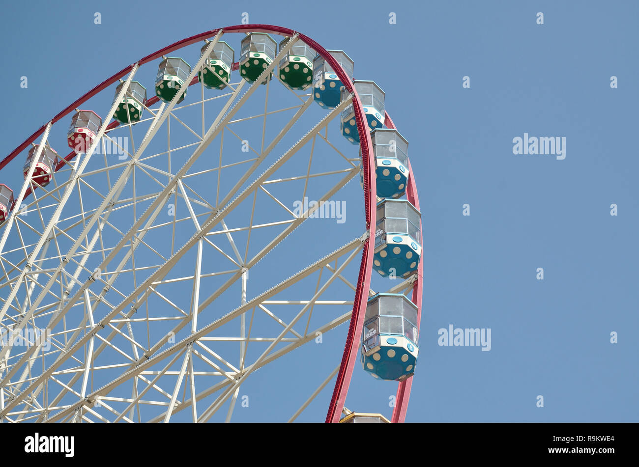 Big and modern multicolour ferris wheel on clean blue sky background ...