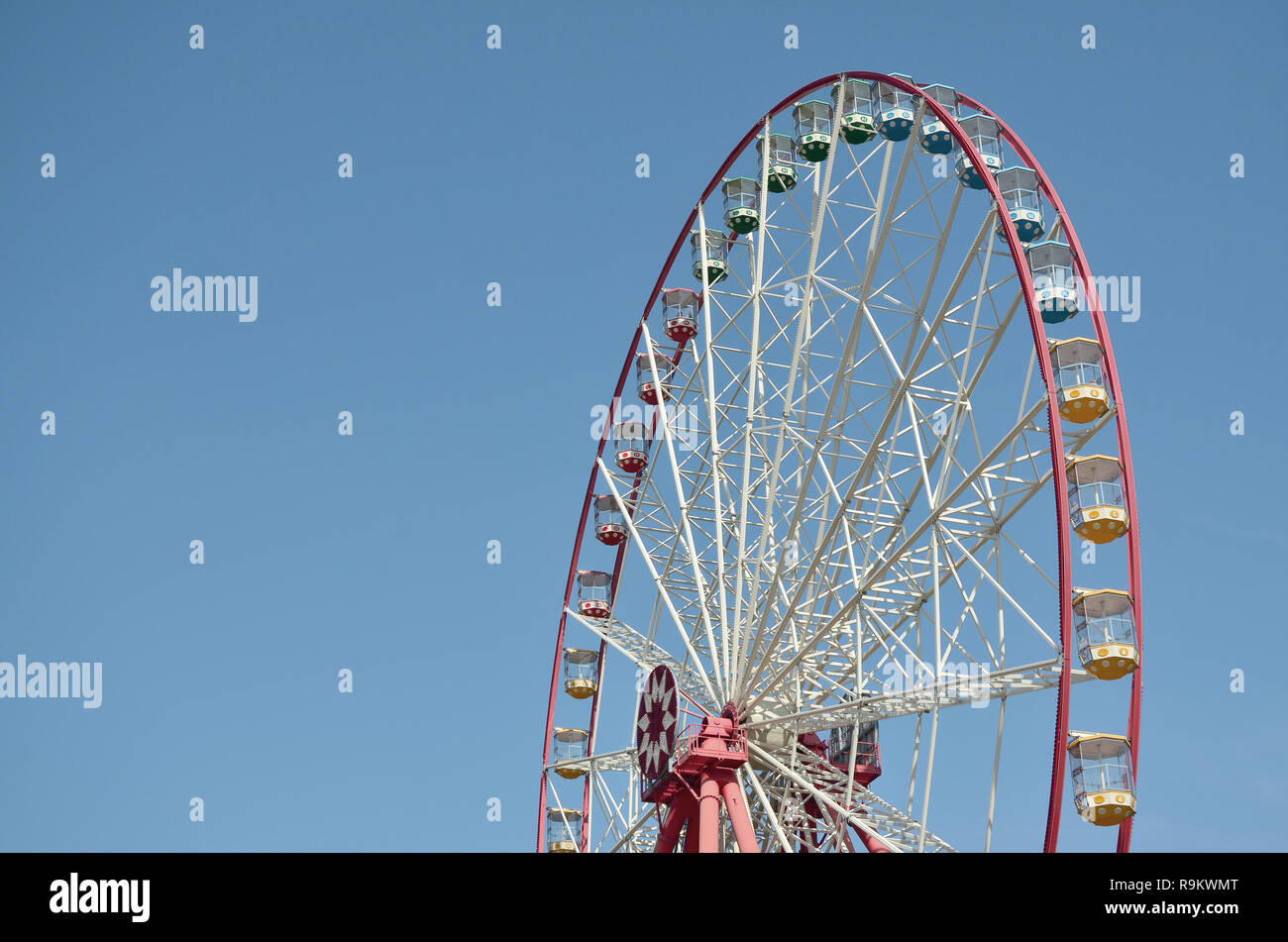 Big and modern multicolour ferris wheel on clean blue sky background ...