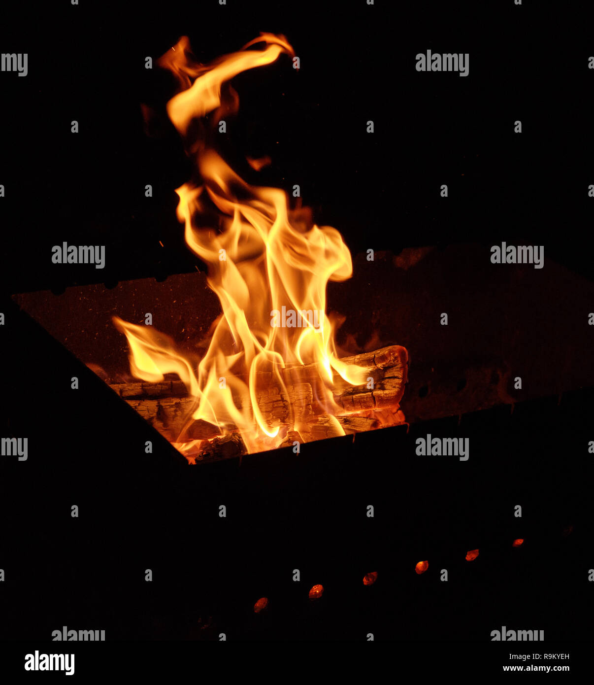 burning wooden logs and large orange flame on a black background Stock