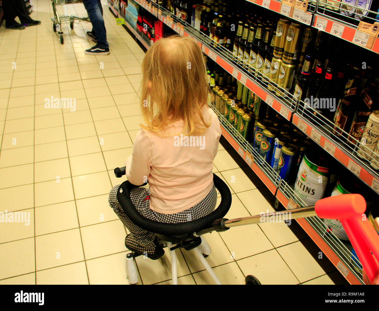Little child sitting in trolley during family shopping in hypermarket. Shopping in supermarket
