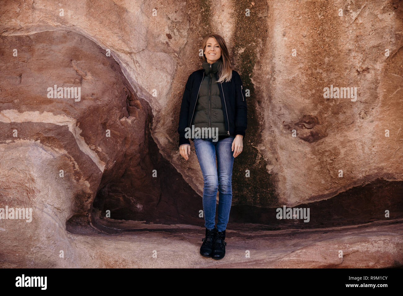Black and White Portrait of Beautiful Attractive Young Modern Fashion Adult Model in Front of Natural Old Ancient Stone Red Rock Wall Background Stock Photo