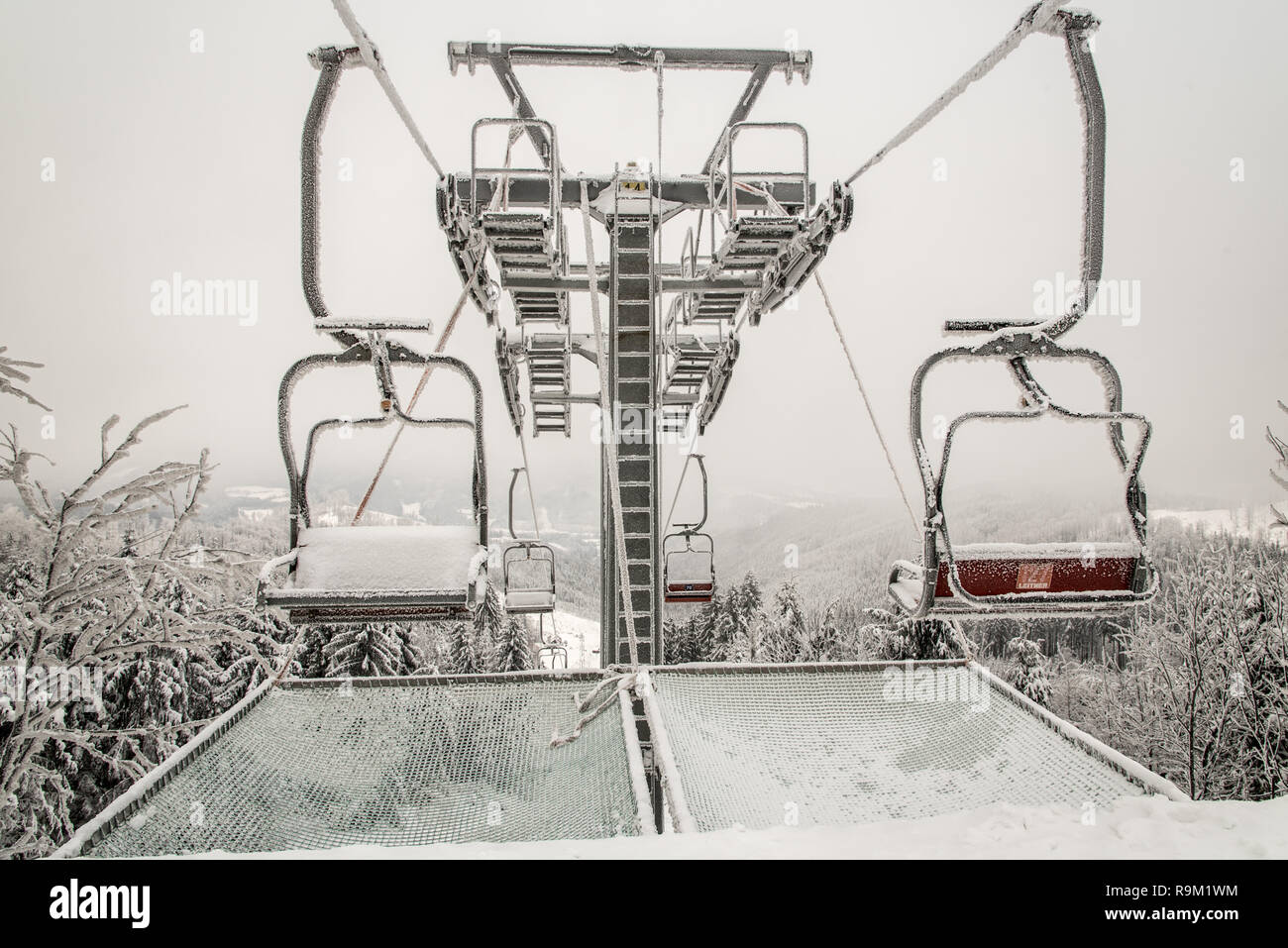 new chair lift on Severka ski area in Moravskoslezske Beskydy mountains in Czech republic during cloudy winter day Stock Photo