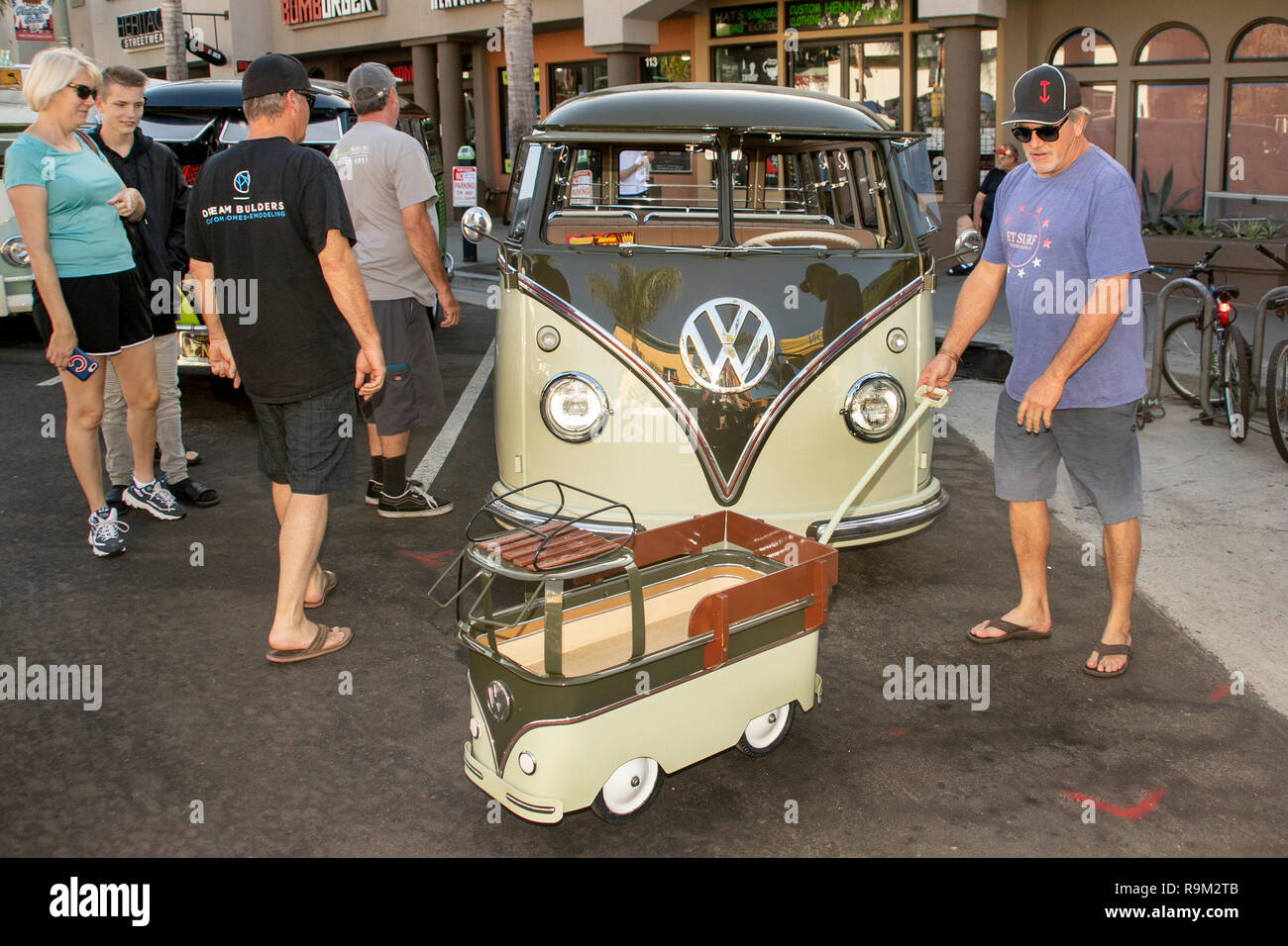 The owner of a classic 1961 Volkswagen van shows off a junior-size mascot in the form of a wagon replica of his vehicle at an antique car show in Huntington Beach, CA. Stock Photo