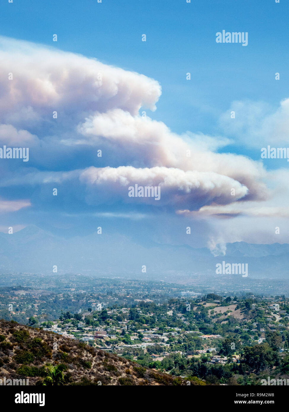 Clouds of smoke from a brush fire spread over a mountain in suburban Laguna Niguel, CA. Stock Photo