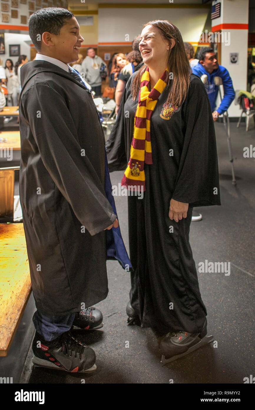 Wearing wizard's robes and scarfs in Hogwarts House colors, two Harry Potter devotees chat at an ice skating event in honor of Potter author J.K. Rowling in Anaheim, CA. Stock Photo