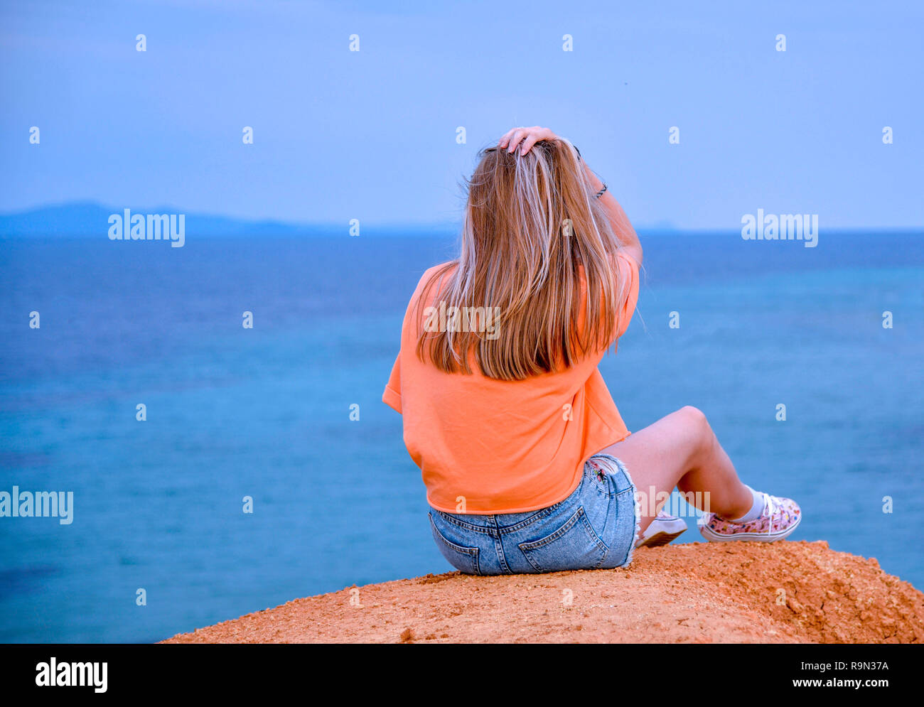 Woman Sitting On Edge Cliff Stock Photos & Woman Sitting On Edge Cliff