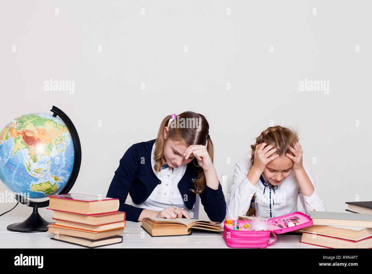 two schoolgirls girls in class at her desk with books notebooks Stock ...