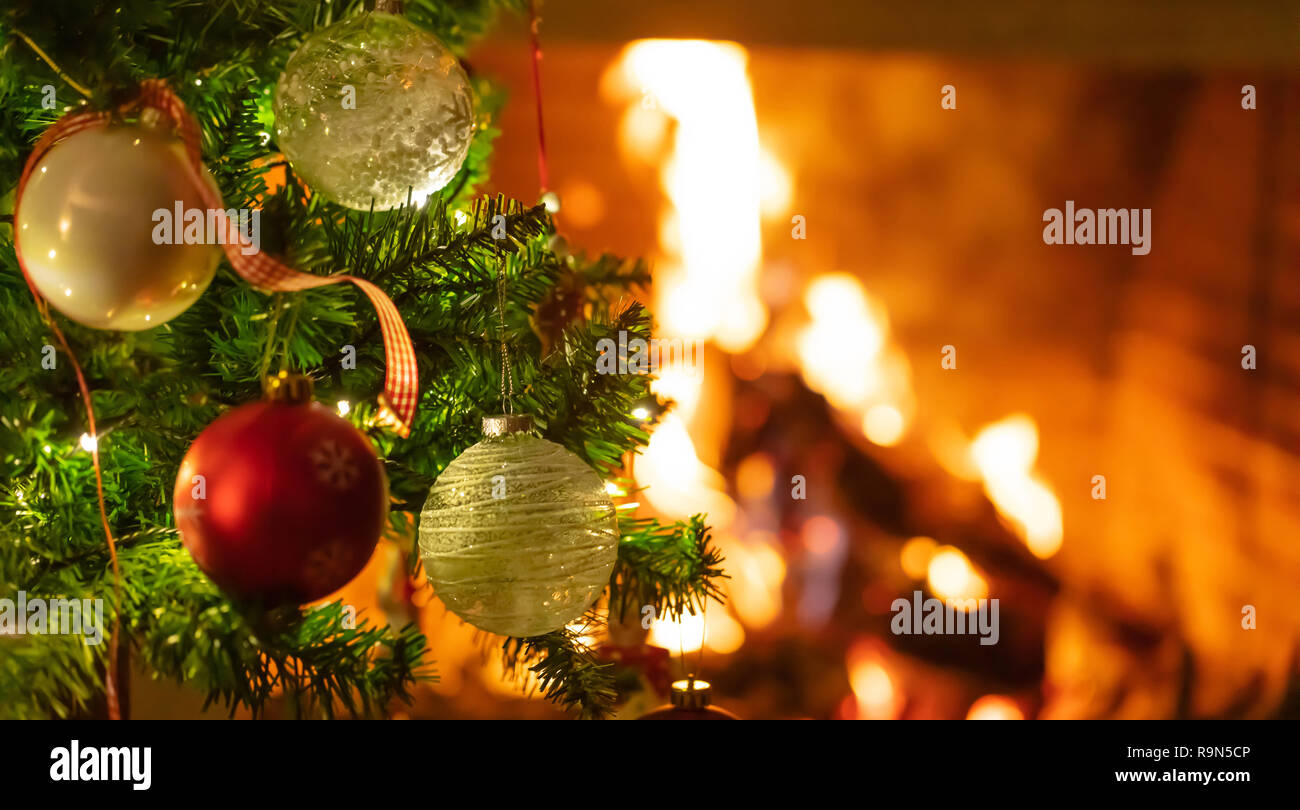 Christmas time, warm home. Christmas tree close up on blurred burning