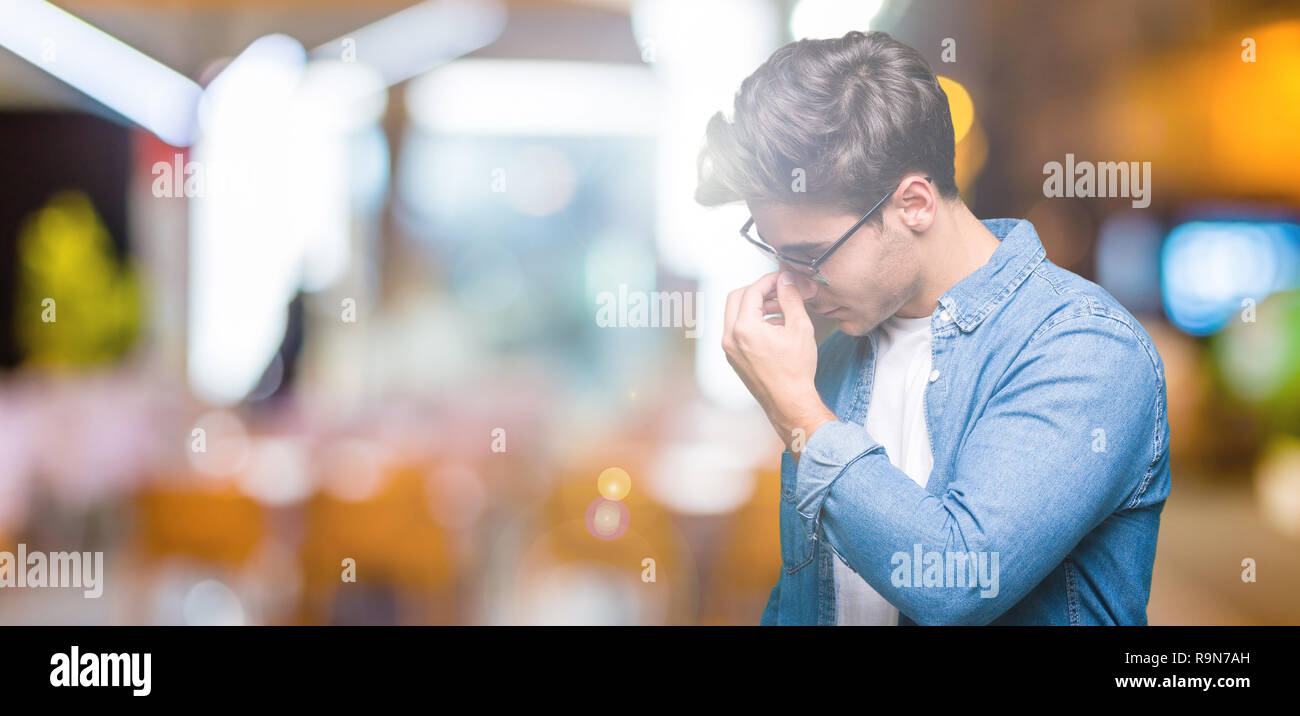 Young handsome man wearing sunglasses over isolated background tired