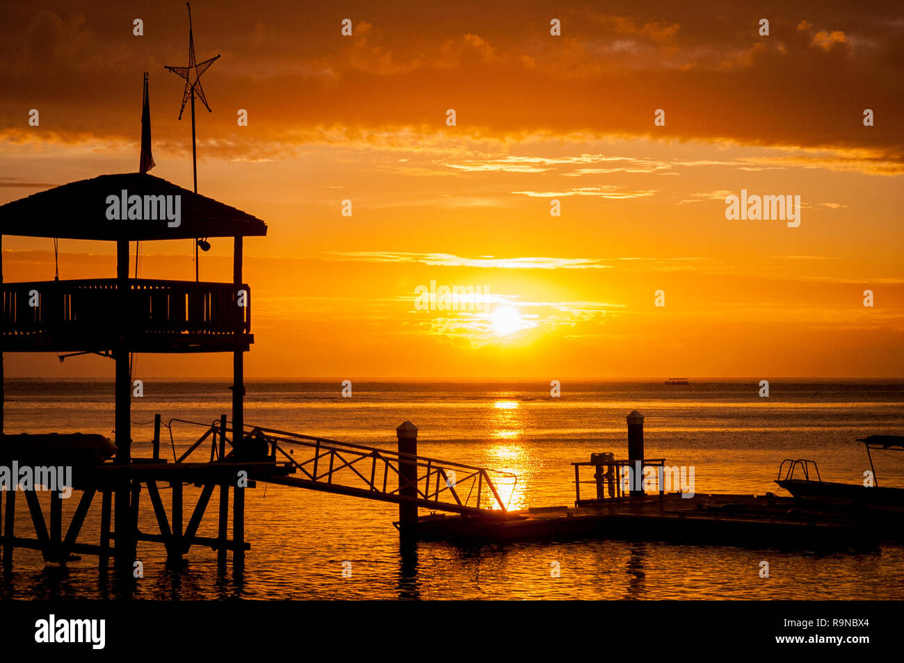 Tropical island sunset with a wharf in the foreground on the Coral Coast in Fiji. Great screensaver! Stock Photo