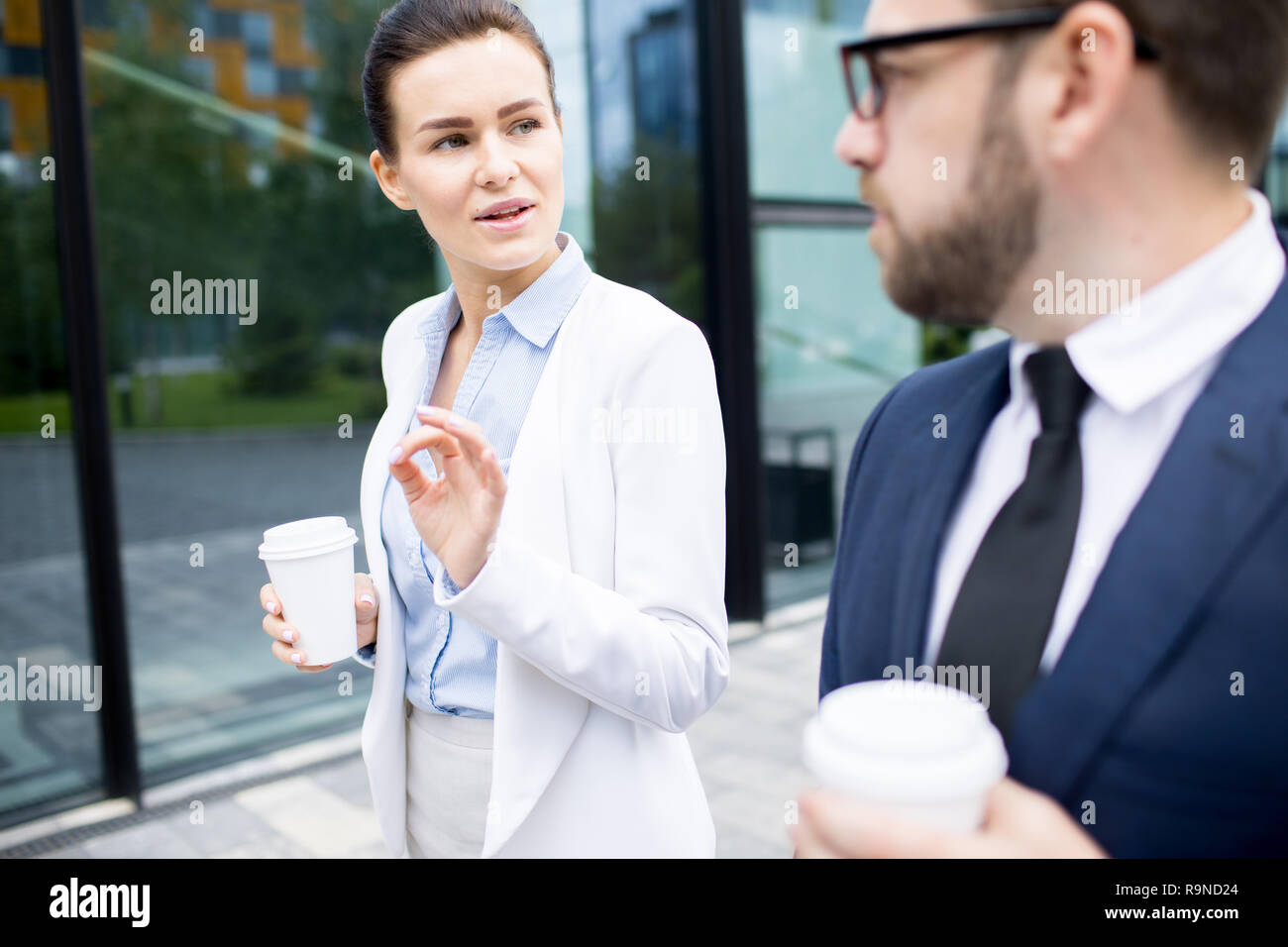 Business people with paper cups walking and talking Stock Photo - Alamy