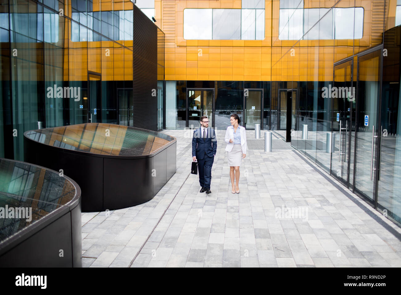 Talking coworkers walking on building terrace Stock Photo