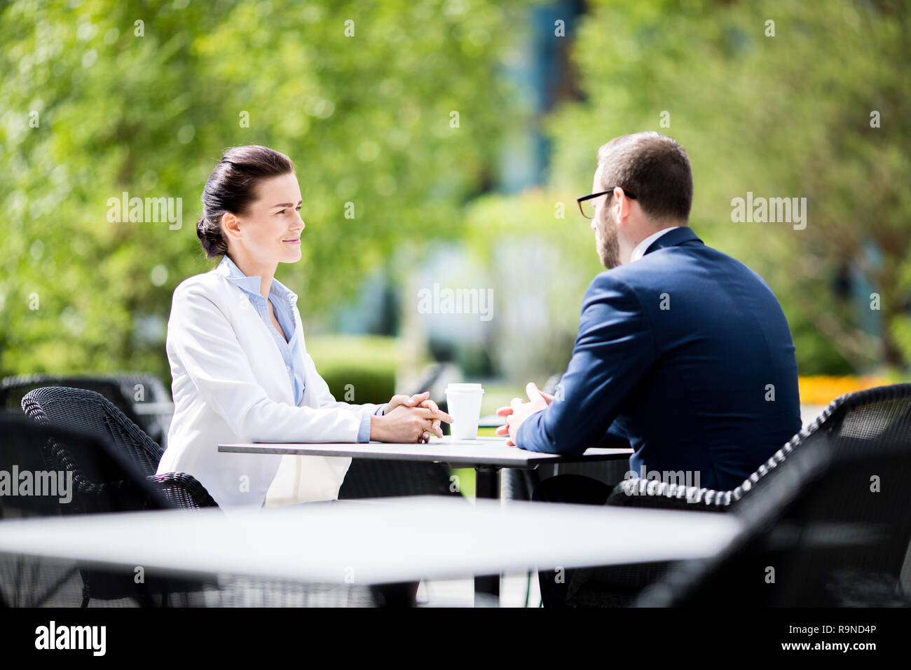 Man and woman sitting at cafe and having dialogue Stock Photo