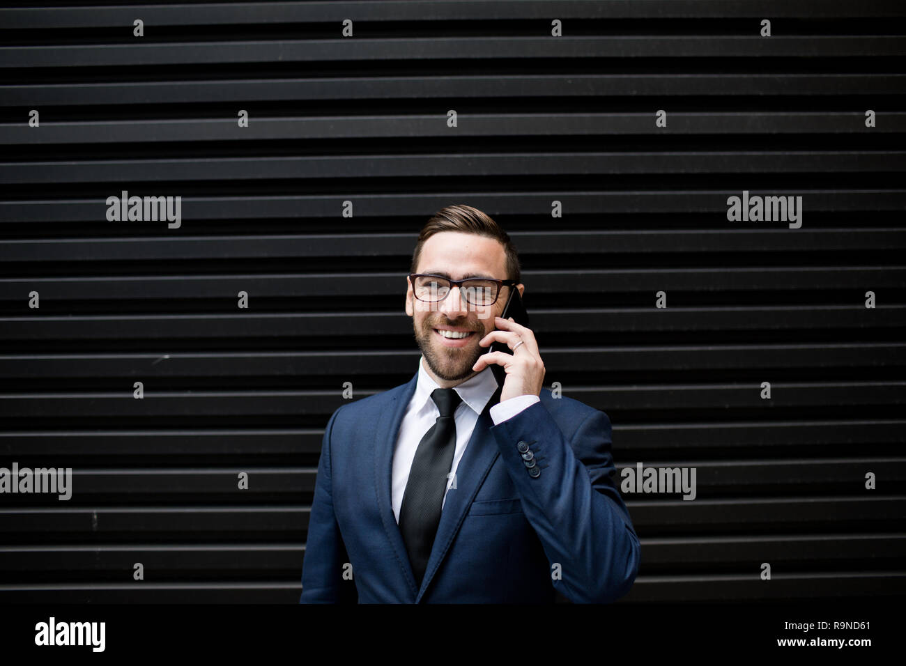 Laughing business man with smartphone Stock Photo