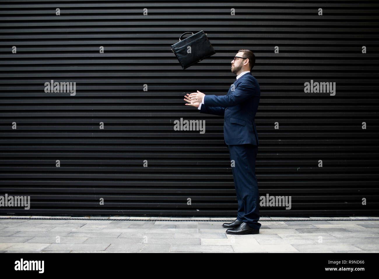 Businessman tossing briefcase Stock Photo