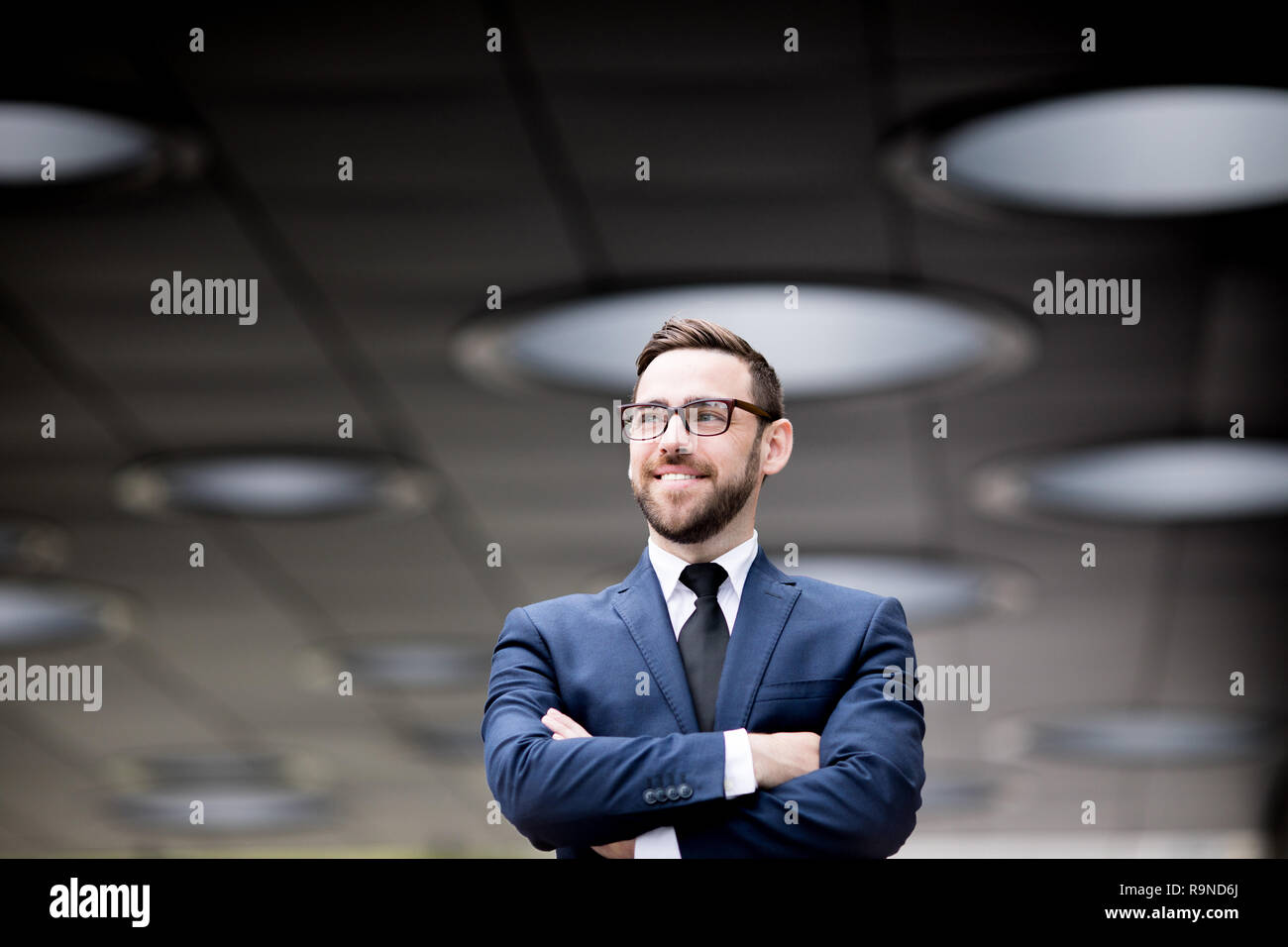 Smiling man crossing hands Stock Photo