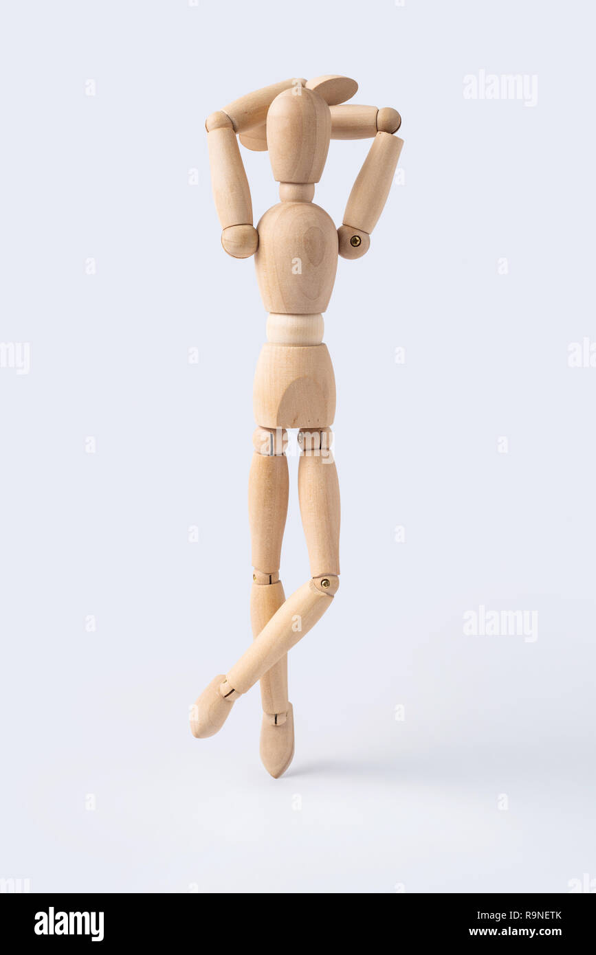 wooden mannequin sitting on black background in horizontal profile