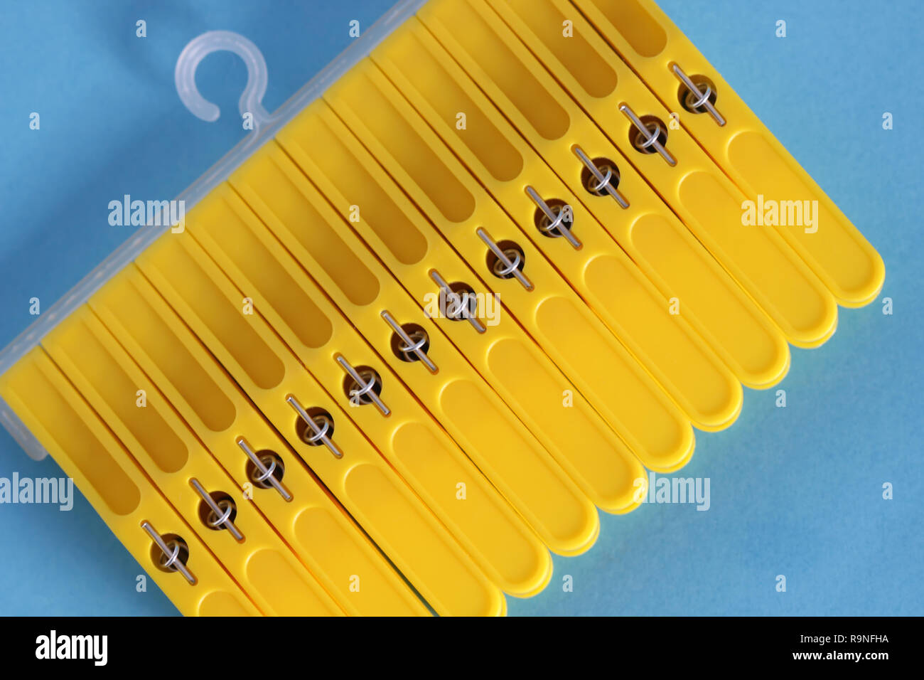 Yellow clothes pins isolated on blue background Stock Photo