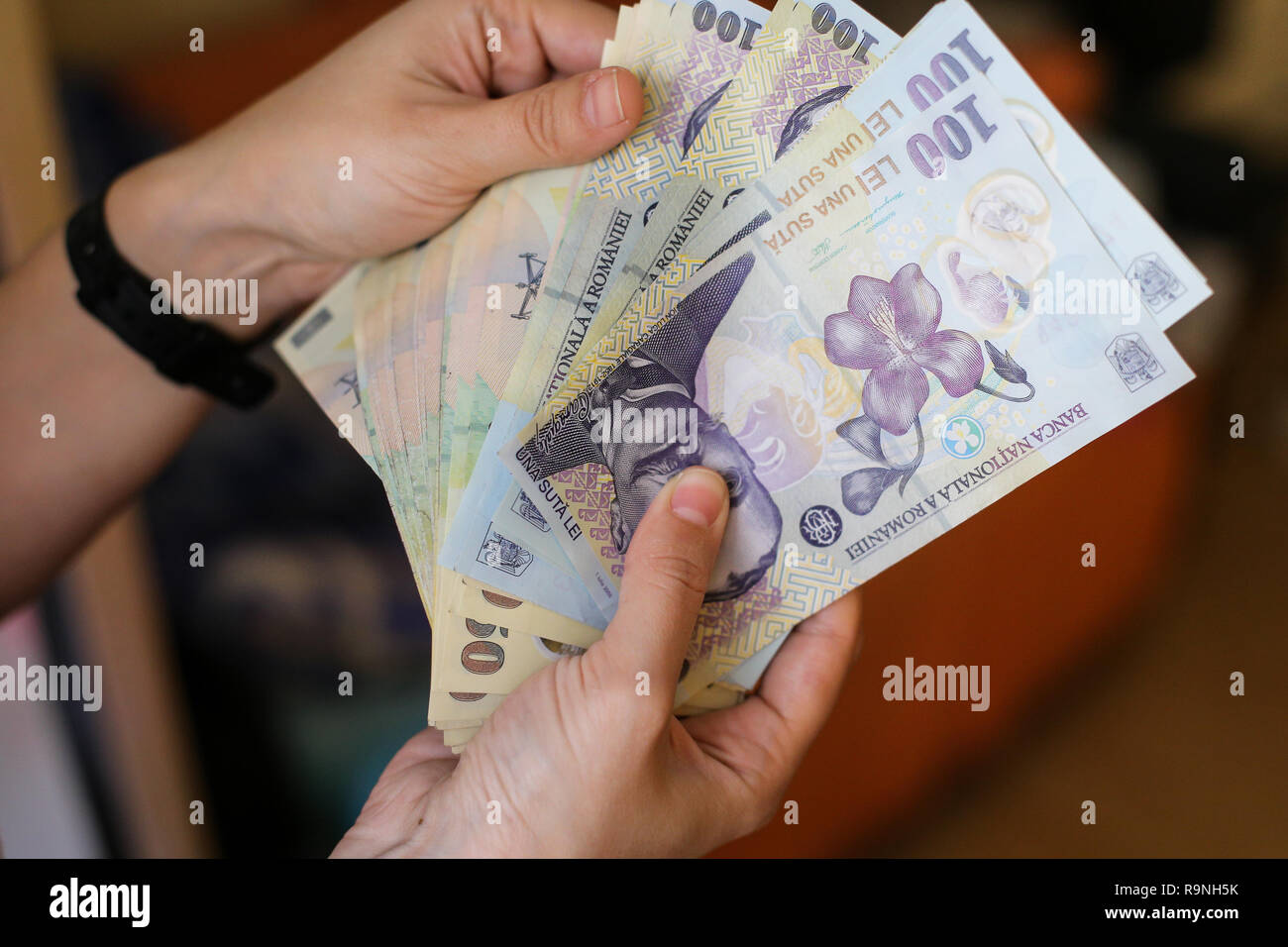 details-with-the-hands-of-a-young-lady-counting-banknotes-of-50-and-100
