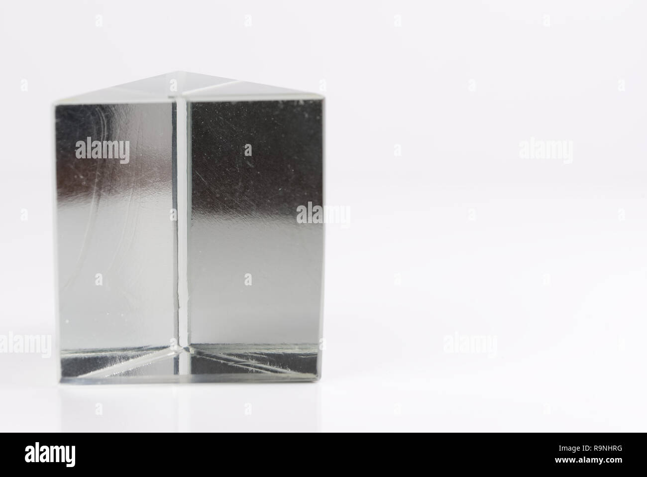 Triangular, clear glass prism isolated on a white background Stock