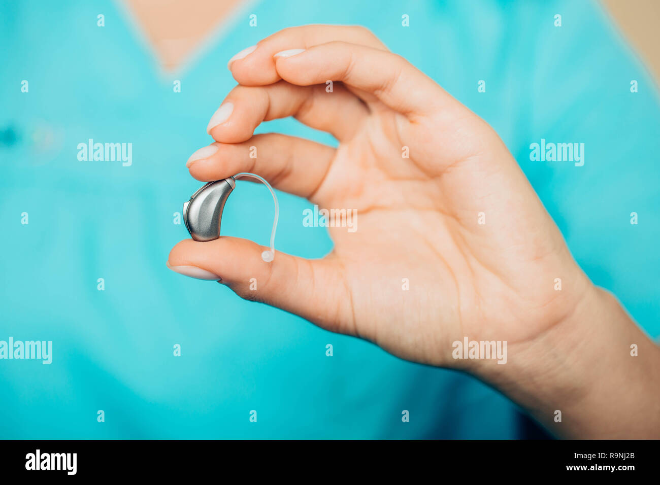 Closeup of a doctors hand holding modern hearing aid. hearing aids