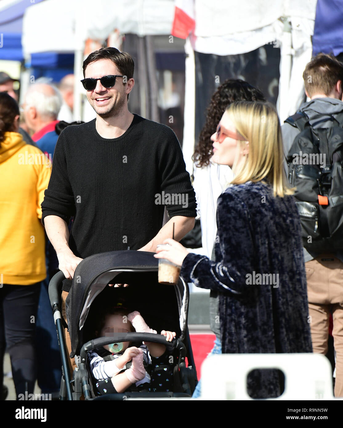 Topher Grace goes to the Farmers Market with his wife and their baby