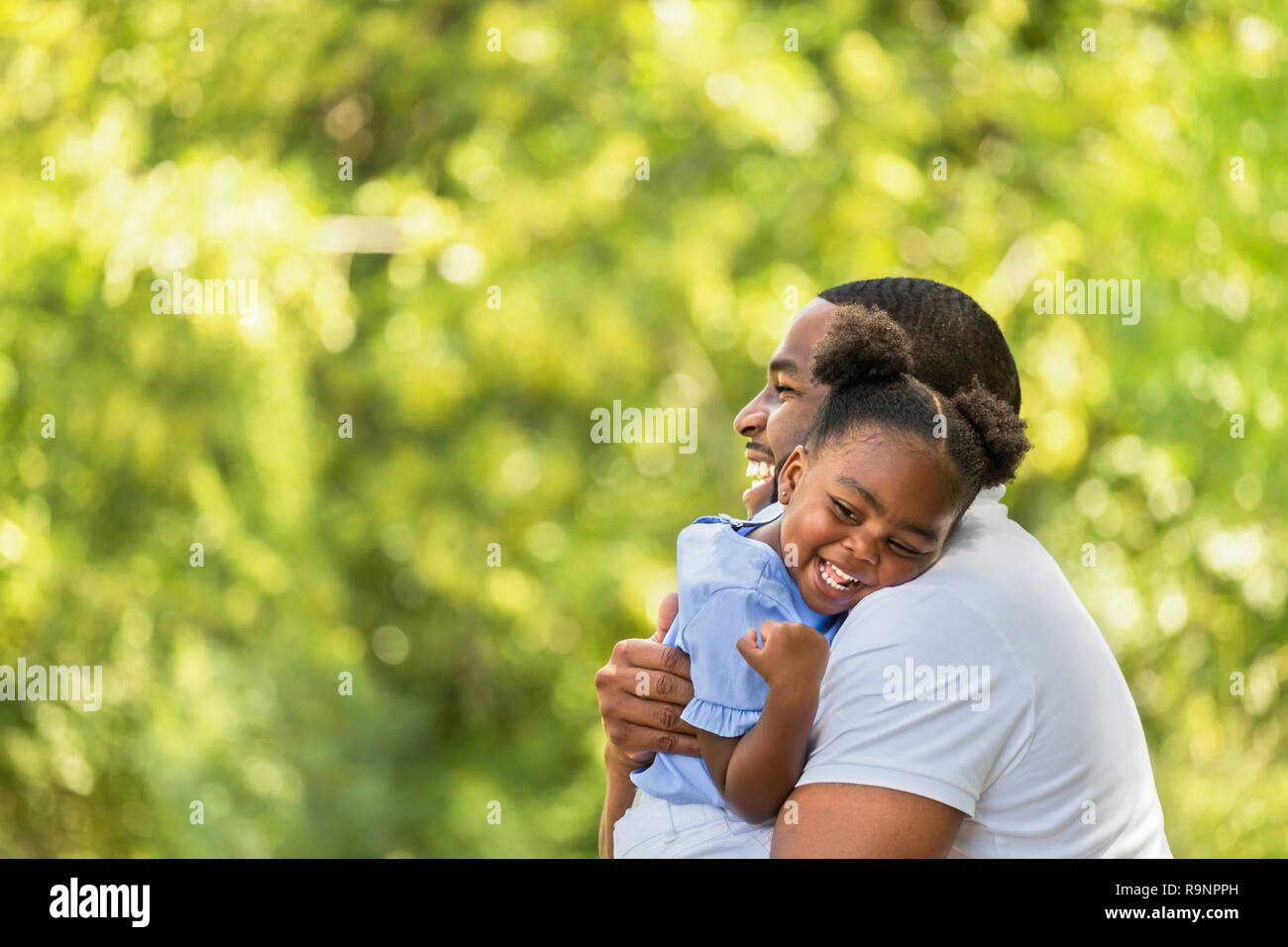 African American father hugging and holding his little girl Stock Photo ...