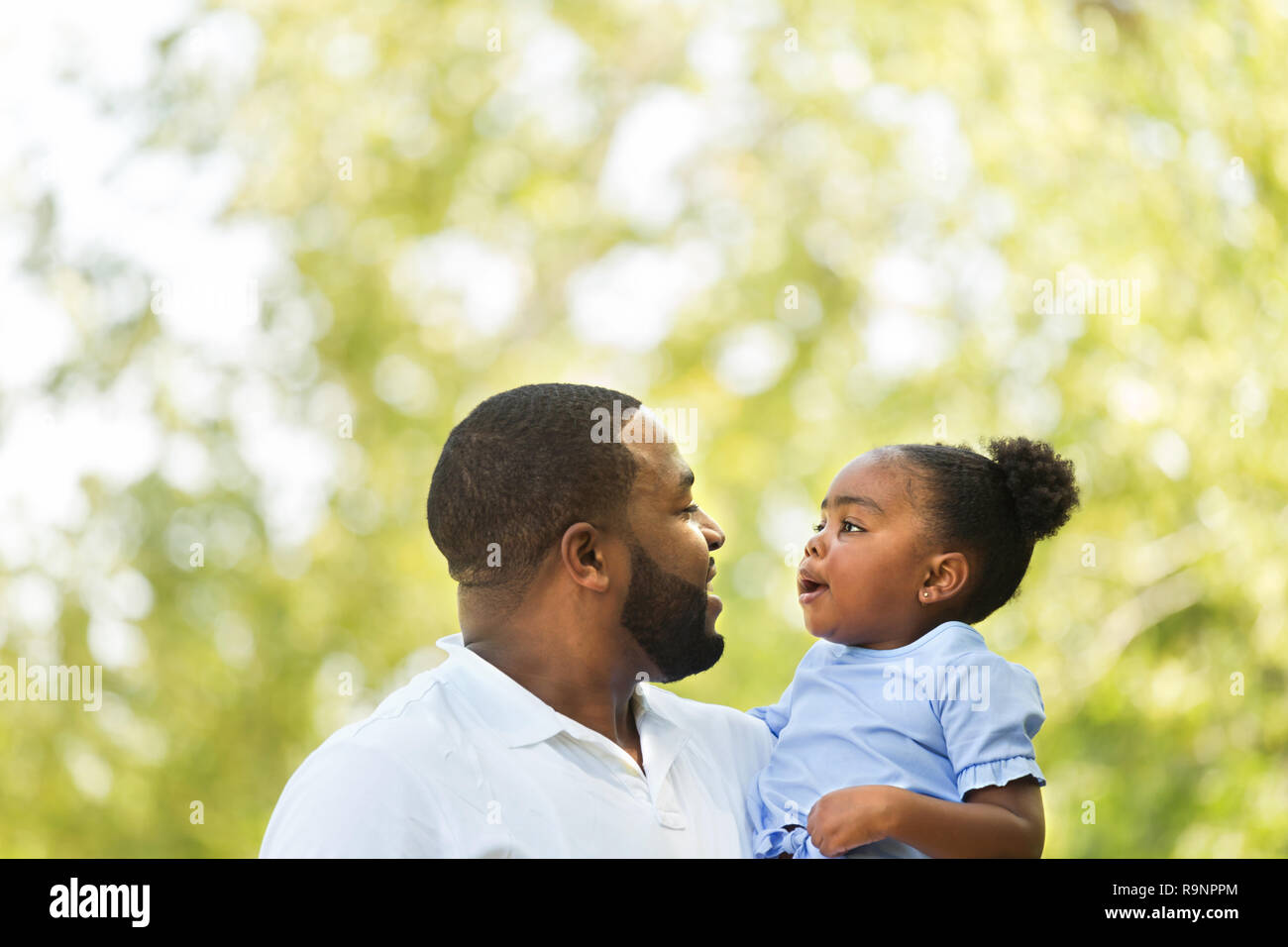 African American father hugging and holding his little girl Stock Photo ...