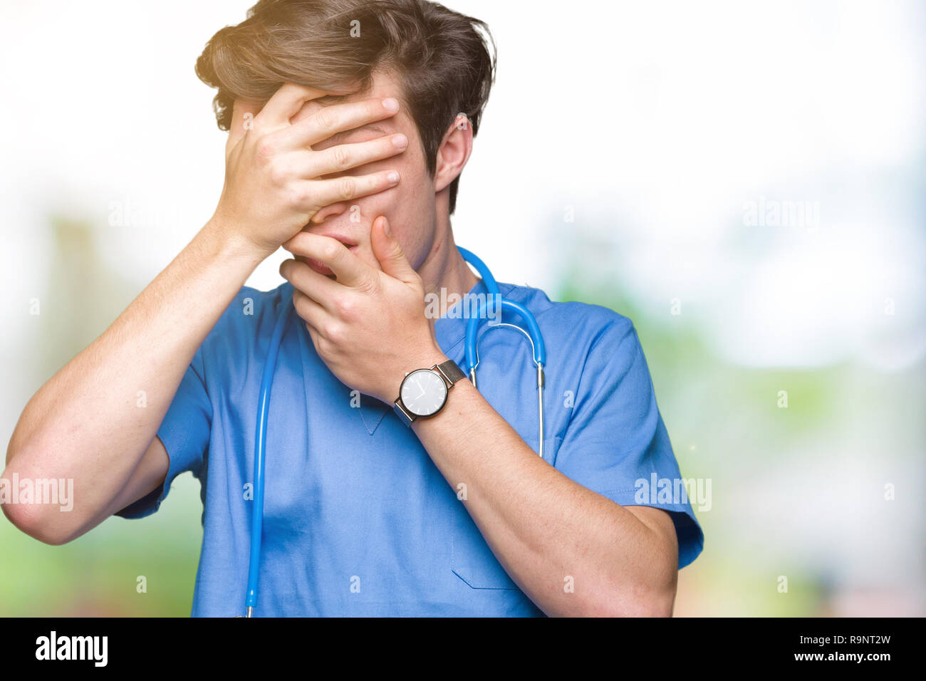 Young doctor wearing medical uniform over isolated background Covering ...