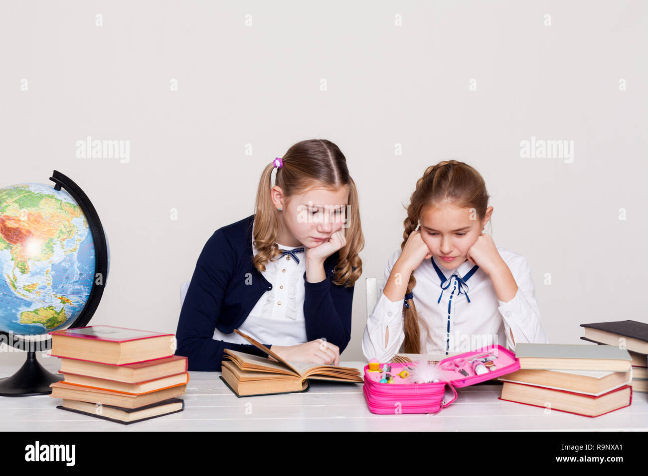 two schoolgirls girls in class at her desk with books notebooks Stock ...