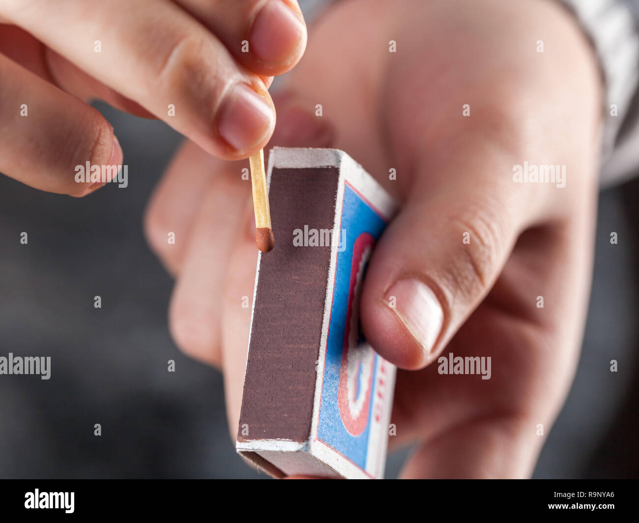 hold a matchbox while striking a match Stock Photo Alamy