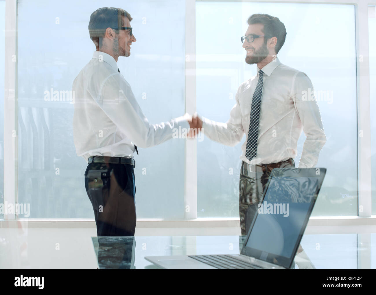 business people shake hands standing in a bright office Stock Photo - Alamy