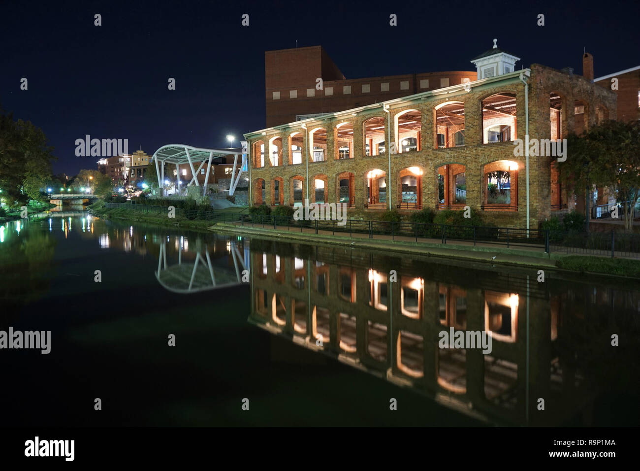 Lights from the Wyche Pavilion reflecting in the Reedy River in Downtown Greenville South Carolina Stock Photo