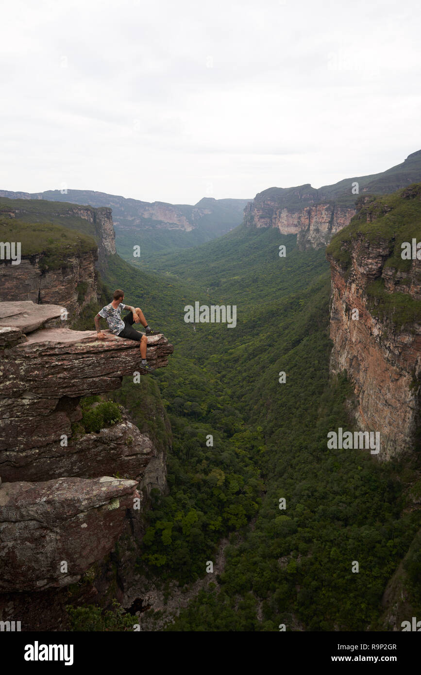 Hiker sitting on the top of a cliff Stock Photo