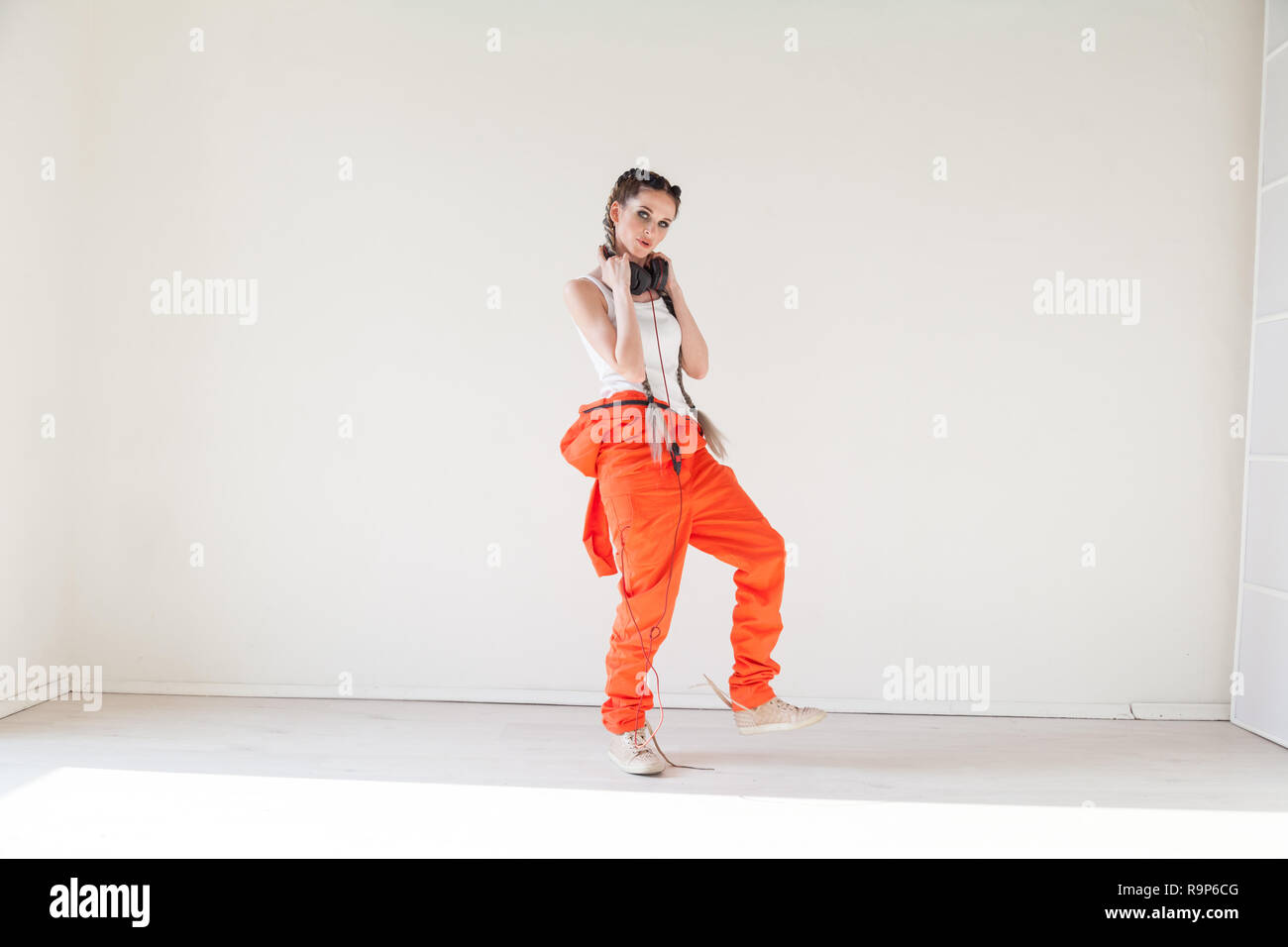 beautiful fashionable woman with braids dancing work overalls Stock Photo -  Alamy