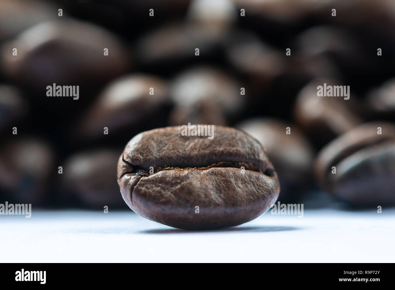 Roasted coffee bean with heap of beans in the background Stock Photo ...