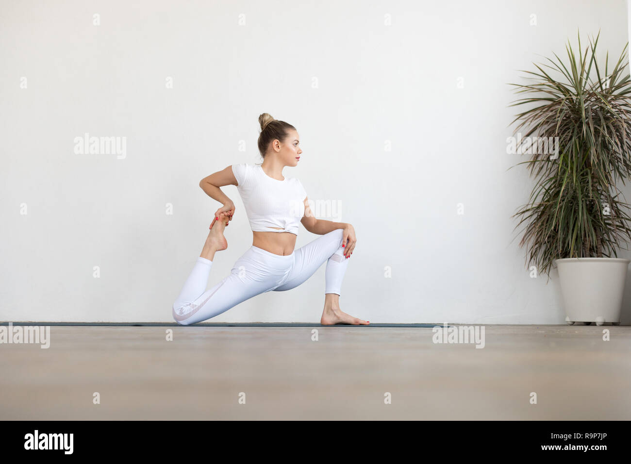 Sporty young woman doing yoga practice on white background Stock Photo ...