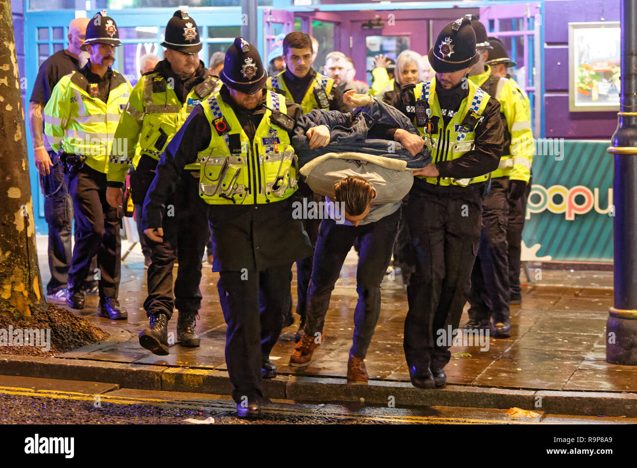 Pictured: A man is handcuffed and removed by police officers in Wind  Street, Swansea, south Wales, UK. Friday 21 December 2018 Re: Black Eye  Friday, a Stock Photo - Alamy