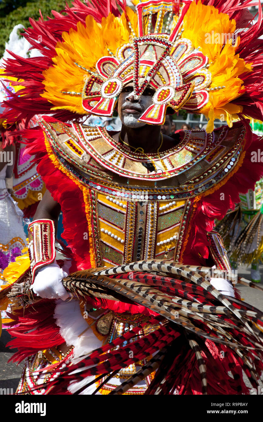 NASSAU, THE BAHAMAS - JANUARY 1 - Male dancer dressed in orange and red feathers, dances in Junkanoo, a traditional island cultural festival in Nassas Stock Photo