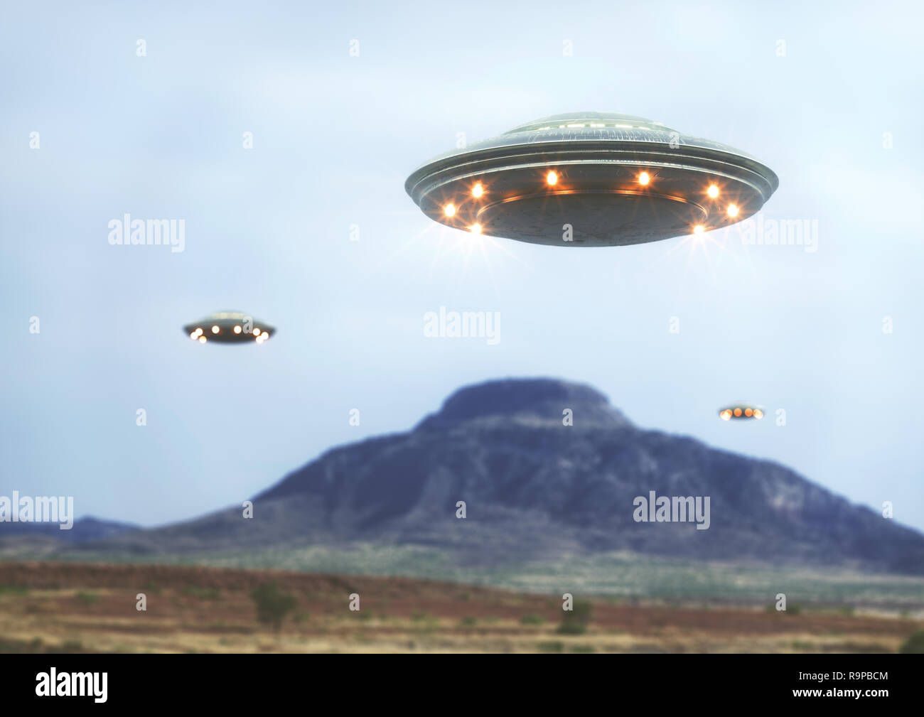 Unidentified flying object over the desert with a mountain behind. Stock Photo